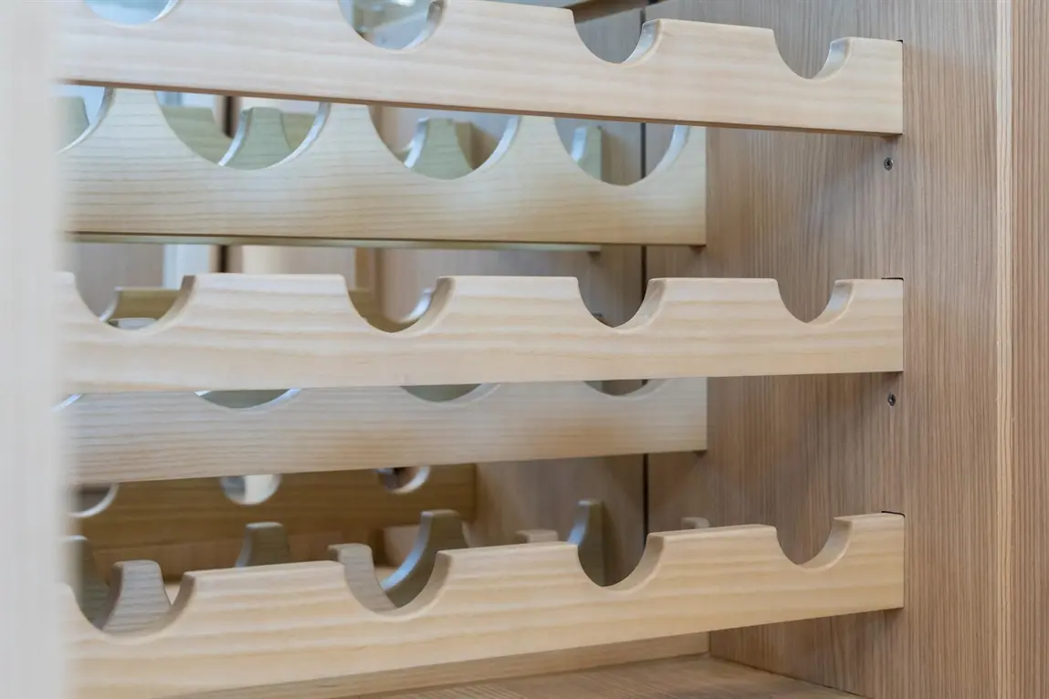 Wooden wine rack displaying multiple horizontal slots for bottles, featuring smooth finishes and a simple design.